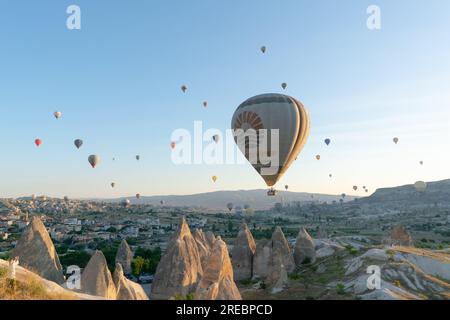 Goreme, Turquie, le 18 juillet 2023 : un ballon survole la Cappadoce, tirant depuis la colline. Banque D'Images