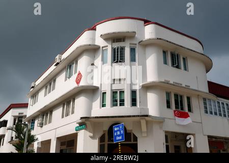 Un bâtiment blanc de style art déco dans Eng Hoon Street, quartier du patrimoine de Tiong Bahru, Singapour, avec des nuages de pluie sombres se profilant au-dessus Banque D'Images