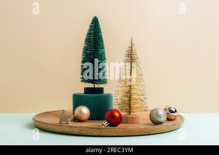 Décorations de Noël, sapins et boules sur un plateau en bois sur fond beige. Concept vacances d'hiver. Banque D'Images