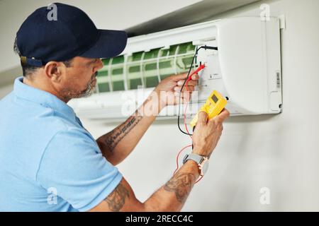 Climatiseur, compteur et électricien homme pour la réparation ac, l'entretien et les services d'alimentation électrique sur le système de ventilateur. Personne, technicien ou entrepreneur Banque D'Images