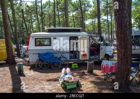 Camping-car, véhicule récréatif sur un parking dans le département de la Gironde (sud ouest de la France). Femme faisant une sieste sur une chaise de plage Banque D'Images