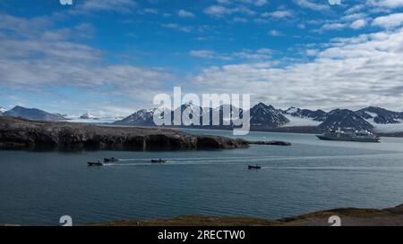 Entourés de glaciers inactifs, les zodiacs du vent d’argent se rendent à Blomstrandøya pour préparer une expédition à destination de NY-Londres. Banque D'Images