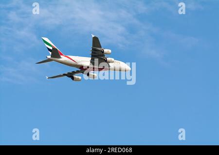 Un avion de passagers Emirates Airbus 380-861 volant à basse altitude contre un ciel bleu Banque D'Images