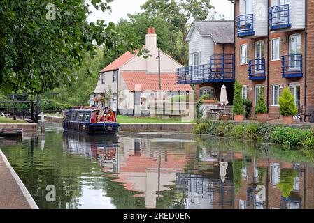 Un petit bateau étroit sortant de Thames Lock sur le canal de navigation de la rivière Wey Weybridge Surrey Angleterre Royaume-Uni Banque D'Images