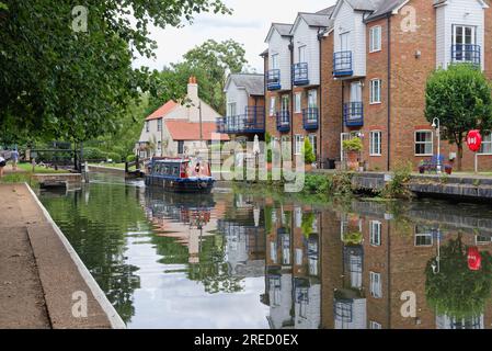 Un petit bateau étroit sortant de Thames Lock sur le canal de navigation de la rivière Wey Weybridge Surrey Angleterre Royaume-Uni Banque D'Images