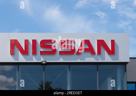 Pologne, Przezmierowo - 27 juillet 2023 : le logo du constructeur automobile Nissan, une entreprise japonaise, contre un ciel bleu vif à l'extérieur. Banque D'Images