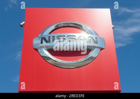 Pologne, Przezmierowo - 27 juillet 2023 : le logo du constructeur automobile Nissan, une entreprise japonaise, contre un ciel bleu vif à l'extérieur. Banque D'Images