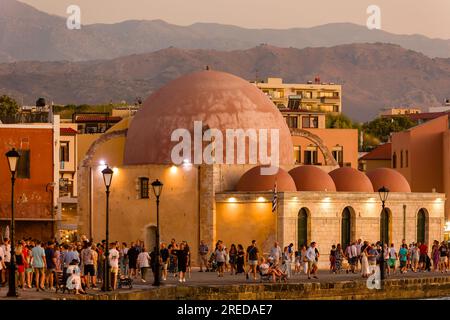 CRÈTE, GRÈCE - JUILLET 03 2023 : foules de touristes dans la soirée près de la vieille mosquée dans le vieux port vénitien de Chania sur l'île de Crète Banque D'Images