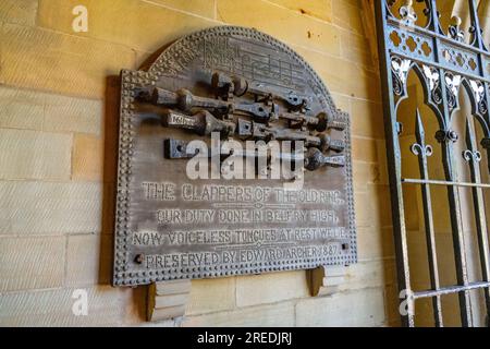 Les vieilles claquettes de cloche montées sur le mur de l'église prieurée de Malvern Banque D'Images