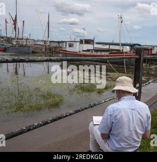 Artiste peinture en plein air, une scène de Thames Sailing Parges à marée basse dans le hameau pittoresque de PIN Mill, Suffolk Banque D'Images