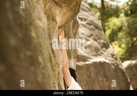 Un grimpeur au loin à l'escalade rochers rochers et arbres dans la forêt d'escalade et de blocs de Fontainebleau près de Paris en France Banque D'Images