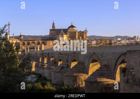 Les premiers rayons du soleil brillent à travers les arches de l'ancien pont romain en pierre sur le fleuve Guadalquivir dans les heures du matin, Cordoue, Espagne Banque D'Images