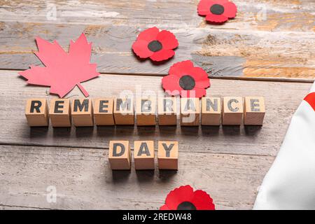 Fleurs de coquelicot avec feuille d'érable sur fond en bois. Jour du souvenir au Canada Banque D'Images