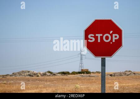 Stop signe, qui a été tiré avec une arme à feu, en arrière-plan, vous pouvez voir des câbles et une tour électrique. Concept : interdite, centrale électrique à la demande Banque D'Images