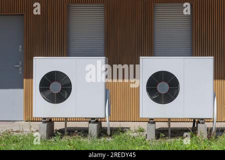 Vue frontale de deux pompes à chaleur à source d'air, un système de chauffage écologique, installé dans une propriété résidentielle moderne. Banque D'Images