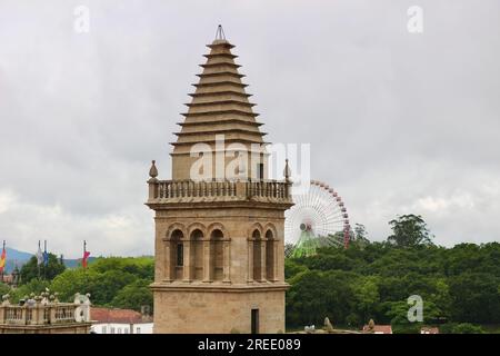 Vue sur le toit de l'une des tours en forme de pyramide de la cathédrale de Santiago avec une grande roue lointaine Santiago de Compostelle Galice Espagne Banque D'Images