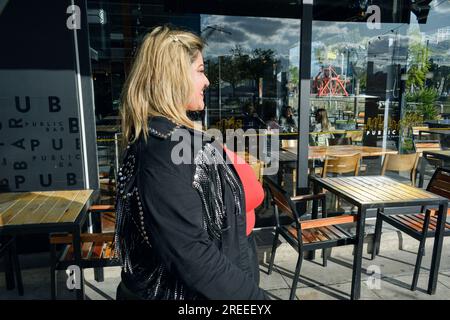 jeune femme latine de grande taille d'origine argentine, sortant du restaurant après avoir mangé, concept d'entreprise, espace de copie. Banque D'Images