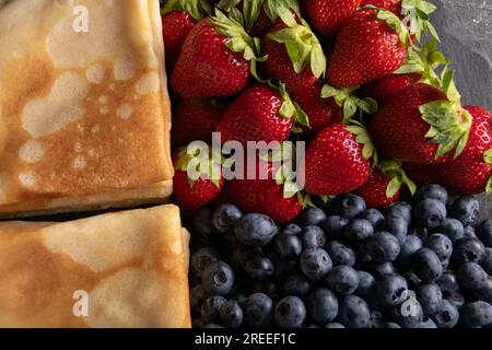 photo de crêpes minces avec fraises mûres et bleuets gros plan Banque D'Images