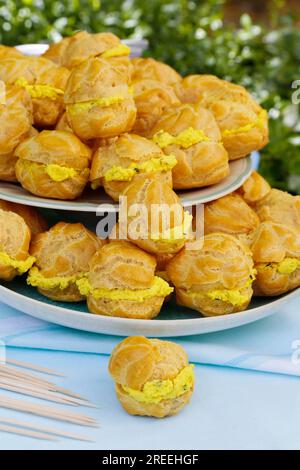 Cuisine souabe, mini choux à la crème garnis de fromage à la crème de chèvre, écheveaux au fromage à la crème, profiterole arrangée sur assiette, sablés, gâteaux au four Banque D'Images