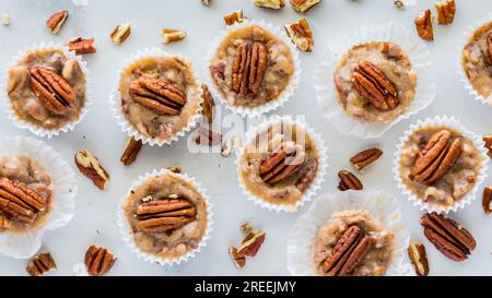 Une vue de haut en bas des tartes aux noix de pécan au caramel salé maison éparpillées. Banque D'Images