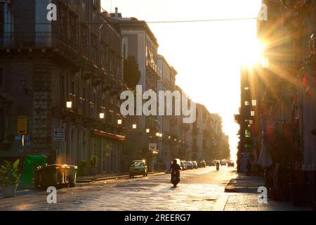 Rétro-éclairage du matin, rue, soleil comme étoile, scooters, voitures, Lanternes, Catane, Vieille ville, Vieille ville baroque, Côte est, Sicile, Italie Banque D'Images