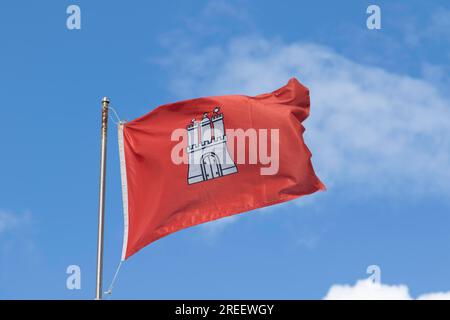 Drapeau rouge avec les armoiries de Hambourg contre un ciel bleu à Hambourg, Allemagne Banque D'Images