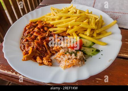 Repas tchèque - katuv sleh (fouettage du bourreau) ragoût de viande épicé avec frites Banque D'Images