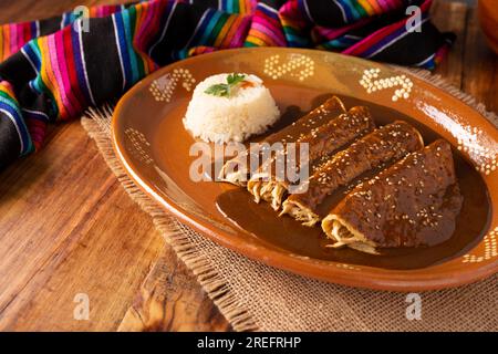 Enmoladas de poulet. Aussi connu sous le nom de mole poblano enchiladas, ils sont un plat mexicain typique qui est très populaire au Mexique et dans le reste du monde. Banque D'Images