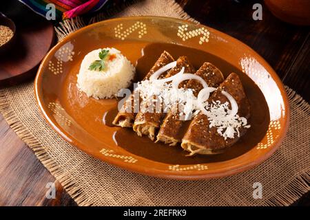 Enmoladas de poulet. Aussi connu sous le nom de mole poblano enchiladas, ils sont un plat mexicain typique qui est très populaire au Mexique et dans le reste du monde. Banque D'Images