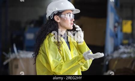 L'inspecteur aux cheveux noirs parle au téléphone avec le directeur de l'usine Banque D'Images