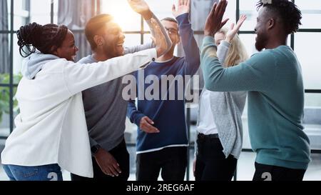 Un groupe de collègues heureux se sentent motivés en donnant cinq Banque D'Images