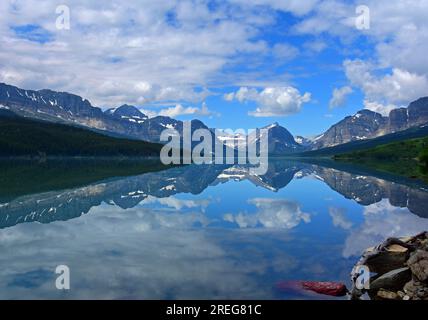 réflexion des nuages et des pics de glacier parc national dans la surface mirrorlike du lac sherburne dans de nombreuses vallées glaciaires, sur le chemin de nombreux glaciers, montana Banque D'Images