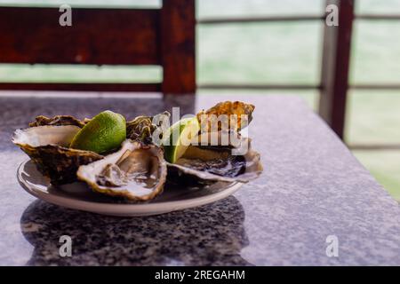 Une assiette d'huîtres servie avec du citron vert Banque D'Images