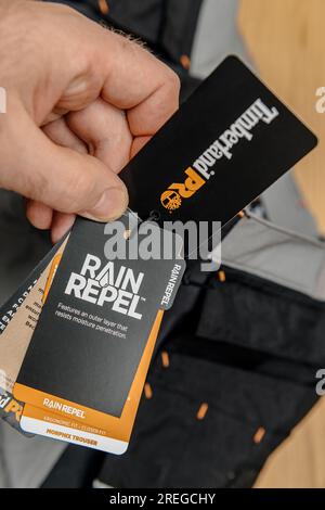 Hambourg, Allemagne - 16 février 2022 : main masculine regardant le pantalon de protection Timberland Pro Work avec coupe ergonomique - tenue avec étiquette avec Rain Repel Banque D'Images