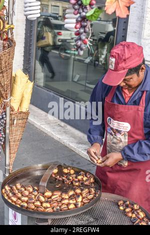 Rome, Italie - 26 novembre 2022 : homme vendant des châtaignes grillées sur un coin de rue à Piazza Navona Banque D'Images