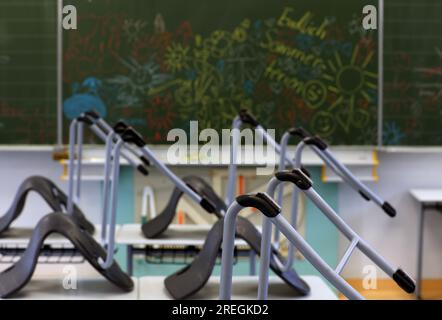 Kaufbeuren, Allemagne. 28 juillet 2023. Les chaises ont été placées sur des bureaux dans une salle de classe dans une école primaire et intermédiaire après la dernière classe avant les vacances d'été. Crédit : Karl-Josef Hildenbrand/dpa/Alamy Live News Banque D'Images