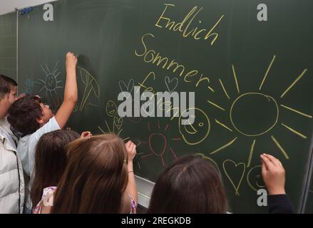 Kaufbeuren, Allemagne. 28 juillet 2023. Les élèves de la classe 4b d'une école primaire et d'un collège peignent leur tableau noir avec des motifs estivaux lors de la dernière leçon avant les vacances d'été. Crédit : Karl-Josef Hildenbrand/dpa/Alamy Live News Banque D'Images