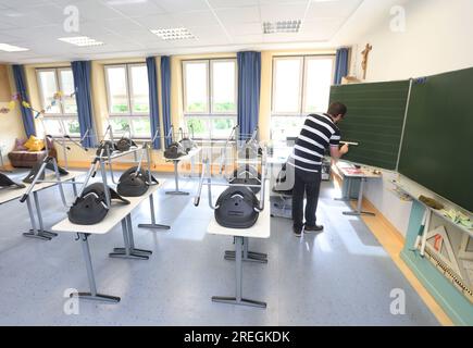 Kaufbeuren, Allemagne. 28 juillet 2023. Un professeur de classe 4b d'une école primaire et intermédiaire essuie le tableau noir après la dernière leçon avant les vacances d'été. Crédit : Karl-Josef Hildenbrand/dpa/Alamy Live News Banque D'Images