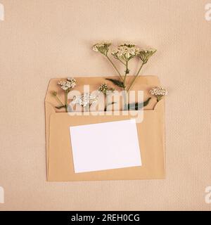 Carte postale minimaliste avec un bouquet de fleurs sauvages dans une enveloppe en gros plan Banque D'Images