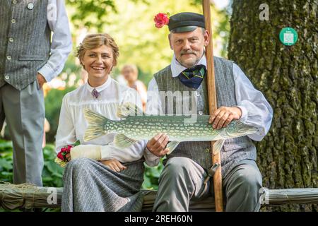 Beau couple souriant dans des vêtements traditionnels et symbole de poisson pendant XXVII chanson lettone nationale et XVII Festival de danse Banque D'Images