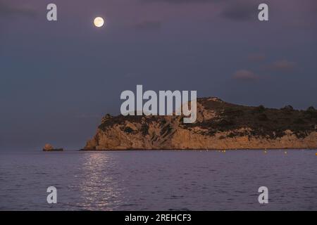 Pleine lune à Cala Blanca à Javea. Vue du Cap Prim. Banque D'Images