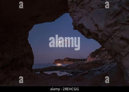 Pleine lune à Cala Blanca à Javea. Vue du Cap Prim. Banque D'Images