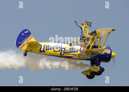 Les wingwalkers d'Aerosuperbatics tout à fait Butterly exposent leur équipe au Royal International Air Tattoo Airshow. Boeing Stearman biplan avec marcheur d'aile Banque D'Images