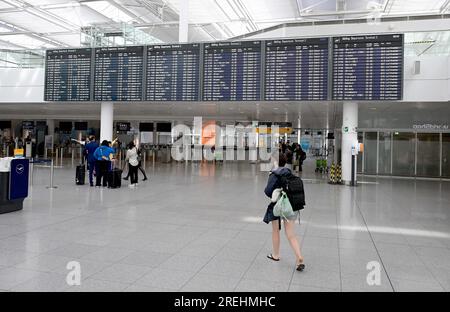 Munich, Allemagne. 28 juillet 2023. Une voyageuse marche vers sa porte dans le terminal 2 de l'aéroport de Munich. Les avions volent le dernier jour d'école avant les vacances d'été en Bavière. Crédit : Felix Hörhager/dpa/Alamy Live News Banque D'Images