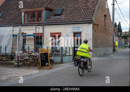 Rumst, province d'Anvers, Belgique, 30 juin 2023- café traditionnel avec cycliste passant devant le musée de pierre de brique Banque D'Images