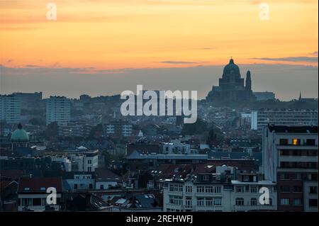 Centre-ville de Bruxelles, Belgique, le 20 juillet 2023 - coucher de soleil jaune sur Molenbeek, Koekelberg et Ganshoren avec la Basilique du Sacré-cœur dans la ba Banque D'Images