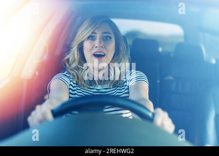 Femme effrayée conduisant une voiture. Banque D'Images