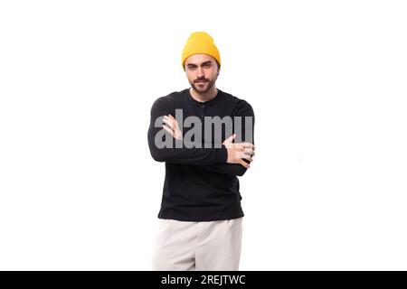 jeune homme brunette caucasien avec une barbe dans un sweat-shirt décontracté se tient en toute confiance sur un fond blanc avec un espace de copie Banque D'Images