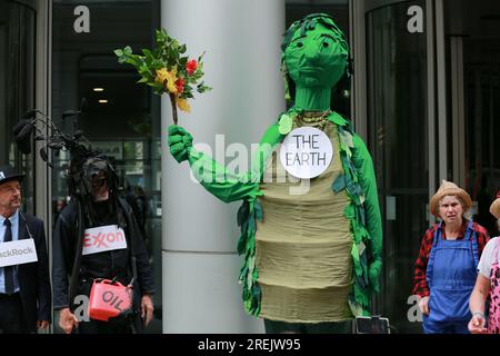 Londres, Royaume-Uni. 28 juillet 2023. Manifestation "Exxon & BlackRock, Your Oil Kills" devant le QG de BlackRock organisée par les militants du climat extinction Rebellion Lewes avec le théâtre de rue Crude Oil Mechanicals. The Crude Oil Mechanicals est un groupe de personnes vivant à Lewes, Brighton et Eastbourne, qui se réunissent pour présenter des spectacles de rue soutenant les manifestations pour la justice climatique. « Unfinished Story » est une pièce complètement nouvelle, mettant en vedette Terre, Soleil, eau, une énorme compagnie pétrolière, un énorme fonds d'investissement, et quelques gens ordinaires. Crédit : Waldemar Sikora/Alamy Live News Banque D'Images