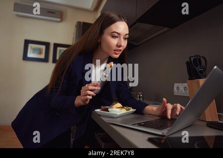 Femme prenant le petit déjeuner et regardant un film dans l'hôtel Banque D'Images